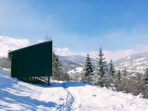 a sign on top of a snow covered hill at Miko II in Slavske