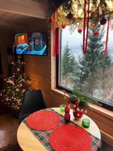 a room with a table with red plates and a christmas tree at Miko II in Slavske +64 photos