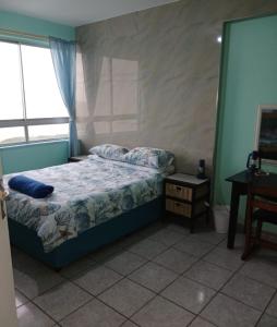 a bedroom with a bed and a desk and a window at Afsaal Sea view apartments in Amanzimtoti