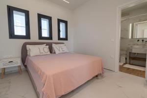 a bedroom with a bed with pink sheets and a mirror at Villa Amelia by Travel Pro - Mouries Halkidiki in Paralia Dionysiou