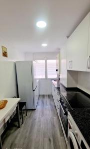 een keuken met witte kasten en een tafel. bij Aloja Burgos in Burgos