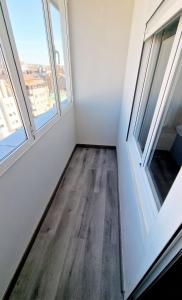 een lege kamer met 2 ramen en een houten vloer bij Aloja Burgos in Burgos +2 foto's