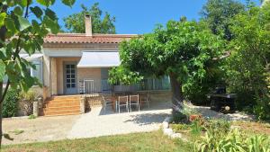 a house with a table and chairs in a yard at Maison avec jardin, Alpilles et Luberon in Sénas
