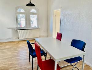 una habitación con una mesa blanca y sillas azules en New Living Nest, en Seevetal
