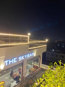 a building with a sign that reads the sky bar at night at Hotel Travel Biz in Medan +3 photos