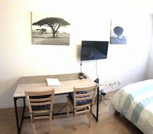 シャンベリにあるStudio ARBOLESのデスク、椅子2脚、ベッド1台が備わる客室です。