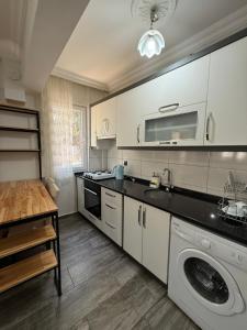 Una cocina con gabinetes blancos y lavadora y secadora. en Eko Homes Fethiye, en Fethiye