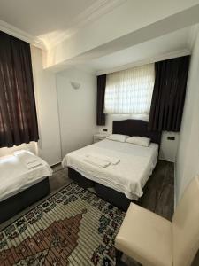 una habitación de hotel con dos camas y una silla en Eko Homes Fethiye, en Fethiye