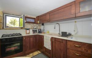 cocina con armarios de madera, fregadero y fogones en Stunning Home In Monterosso Almo, en Monterosso Almo