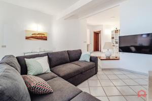 a living room with a couch and a flat screen tv at Delizioso Appartamento in villa & Piscina Privata in Trabia