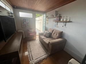 a living room with a couch and a flat screen tv at Pousada Aconchego in Passa Quatro