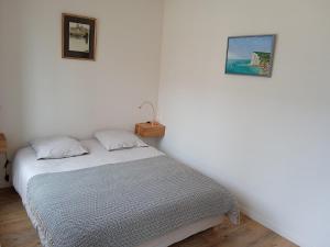 a bed in a room with two pictures on the wall at La Scie - Domaine du Presbytère in La Chapelle-sur-Dun