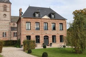 a large brick building with a clock tower at La Scie - Domaine du Presbytère in La Chapelle-sur-Dun