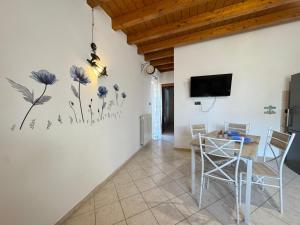 a dining room with a table and a tv on the wall at Chalet sul Mare in Ladispoli