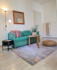 a living room with a green couch and a table at Palacinema Apartment - Locarno Old Town in Locarno