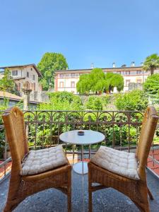 a pair of chairs and a table on a balcony at Palacinema Apartment - Locarno Old Town in Locarno