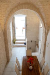 una sala da pranzo con un arco e un tavolo di legno di Il Cuore del Borgo - Terrace In The Old Town a Locorotondo