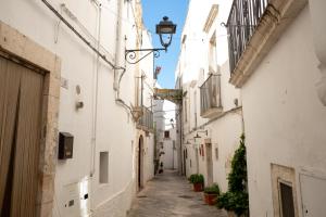 un vicolo in un centro storico con edifici bianchi di Il Cuore del Borgo - Terrace In The Old Town a Locorotondo