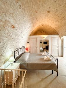 una camera con un grande letto in una parete in pietra di Il Cuore del Borgo - Terrace In The Old Town a Locorotondo