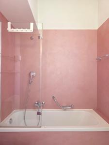 a bathroom with a bath tub with a shower at Palacinema Apartment - Locarno Old Town in Locarno