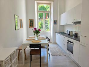 a kitchen with a table with chairs and a vase of flowers at Palacinema Apartment - Locarno Old Town in Locarno +53 photos