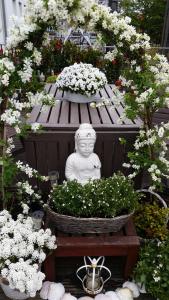 un jardín con una estatua y flores en un banco en Prince On The Roof, en Ámsterdam