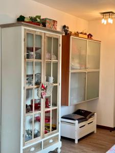 a white cabinet with glass doors in a room at Folghouse in Folgaria