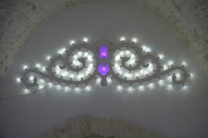 a chandelier with lights on a white wall at Relais I Quattro Cuori in Martina Franca