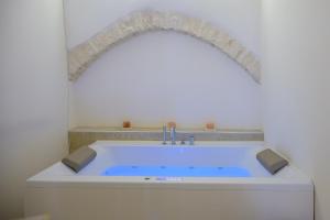 a bath tub in a bathroom with an arch above it at Relais I Quattro Cuori in Martina Franca