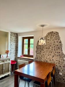 a dining room with a table and a stone wall at Folghouse in Folgaria