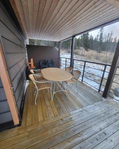 a wooden deck with a table and chairs on it at Leilighet til leie på Synnfjellet in Lii +15 photos