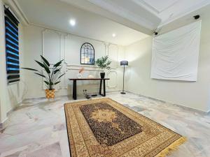 Zimmer mit einem Teppich auf dem Boden und einem Tisch in der Unterkunft PUSAT BANDAR PUCHONG, 47100 Puchong Homestay in Puchong
