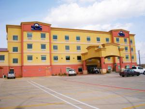 a large yellow and red building with a parking lot at Robinson Inn and Suites in Robinson