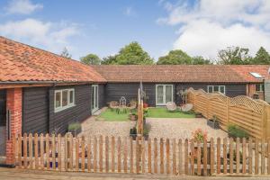 a house with a wooden fence in front of it at Gorgeous rural dog welcoming Milk Churn - Suffolk in Eye +16 photos