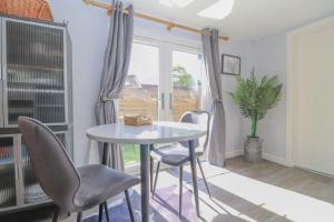 a table and chairs in a room with a window at Gorgeous rural dog welcoming Milk Churn - Suffolk in Eye