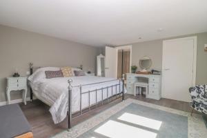 a bedroom with a bed and a desk and a mirror at Gorgeous rural dog welcoming Milk Churn - Suffolk in Eye