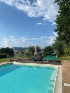 a swimming pool with two chairs at Agriturismo Tenute di Hera - Via Francigena in Acquapendente