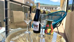 Una botella de vino y dos copas en una mesa en Cloudy Tbilisi Apartment, en Tiflis 11 fotos más