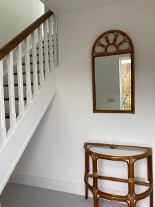 a mirror on a wall next to a stairway at Cillarney Lakeview Loft Apartment in Killarney