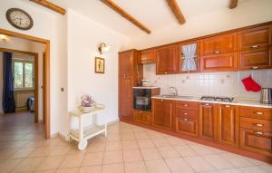 a kitchen with wooden cabinets and a clock on the wall at Baglio Mediterraneo in Borgo Bonsignore