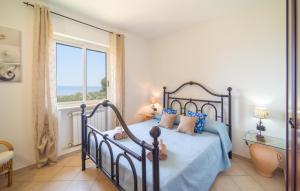 a bedroom with a bed with blue sheets and a window at Baglio Mediterraneo in Borgo Bonsignore