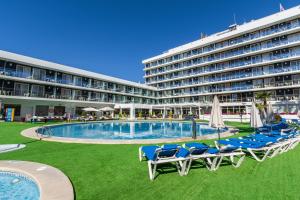 a hotel with a pool and chairs and a building at Hotel Anabel in Lloret de Mar