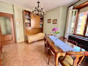 a dining room with a table and chairs and a bedroom at Chez Louise, free wi-fi & 5 minutes from InalpiArena in Turin