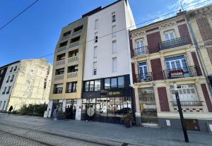 a building on a street with two buildings at B&B HOTEL Le Havre Centre in Le Havre