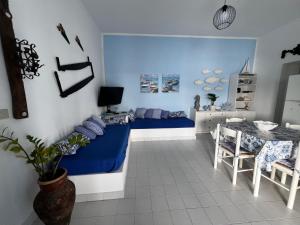 a bedroom with a blue bed and a table at Le casette di nonna Giulia B in Lingua