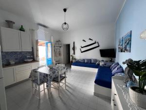 a kitchen and a living room with a couch and a table at Le casette di nonna Giulia B in Lingua