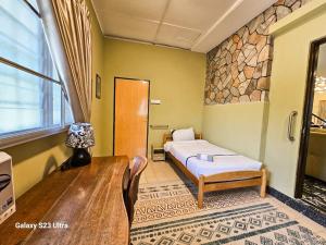 a bedroom with a bed and a stone wall at Lasam Heritage Villa 22pax with Karaoke & Snooker in Ipoh