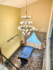 a dining room with a large chandelier and a table at Lasam Heritage Villa 22pax with Karaoke & Snooker in Ipoh