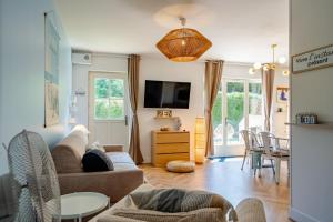 ein Wohnzimmer mit Sofa und Fernseher in der Unterkunft Gite La Goutte d'eau - Baby foot - 6 personnes LITS King & Queen size - Terrasse Vue étang in Saint-Josse