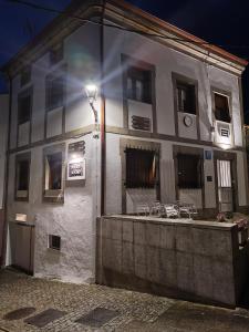 a building with tables and chairs in front of it at Travesia Rooms in Sarria
